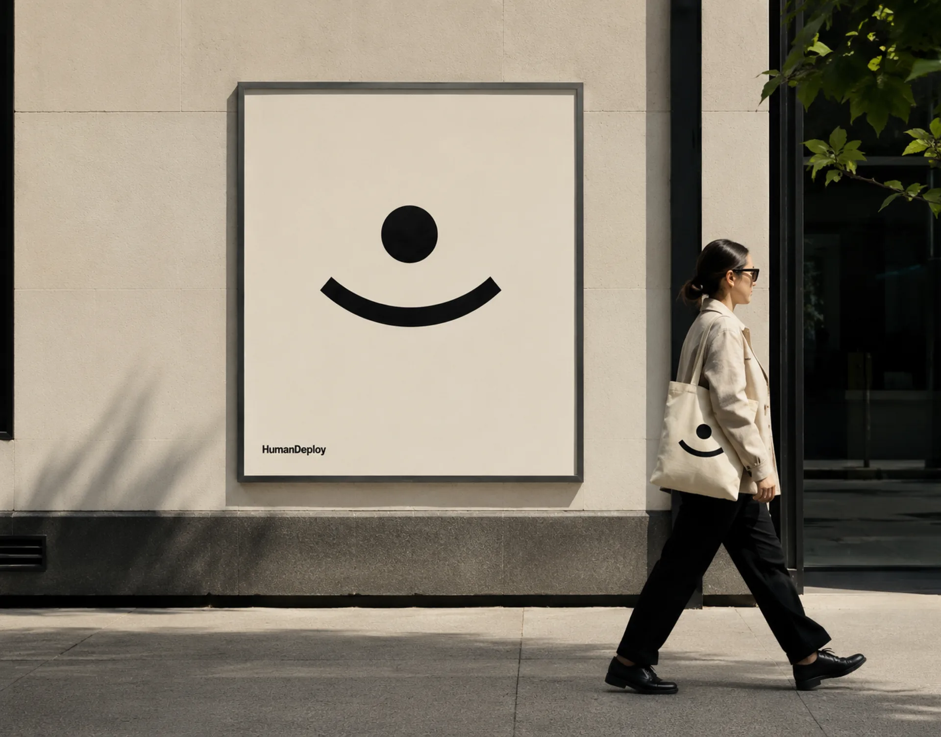 HumanDeploy — A framed HumanDeploy smile-mark poster mounted on a stone storefront as a woman with a branded tote walks past in daylight