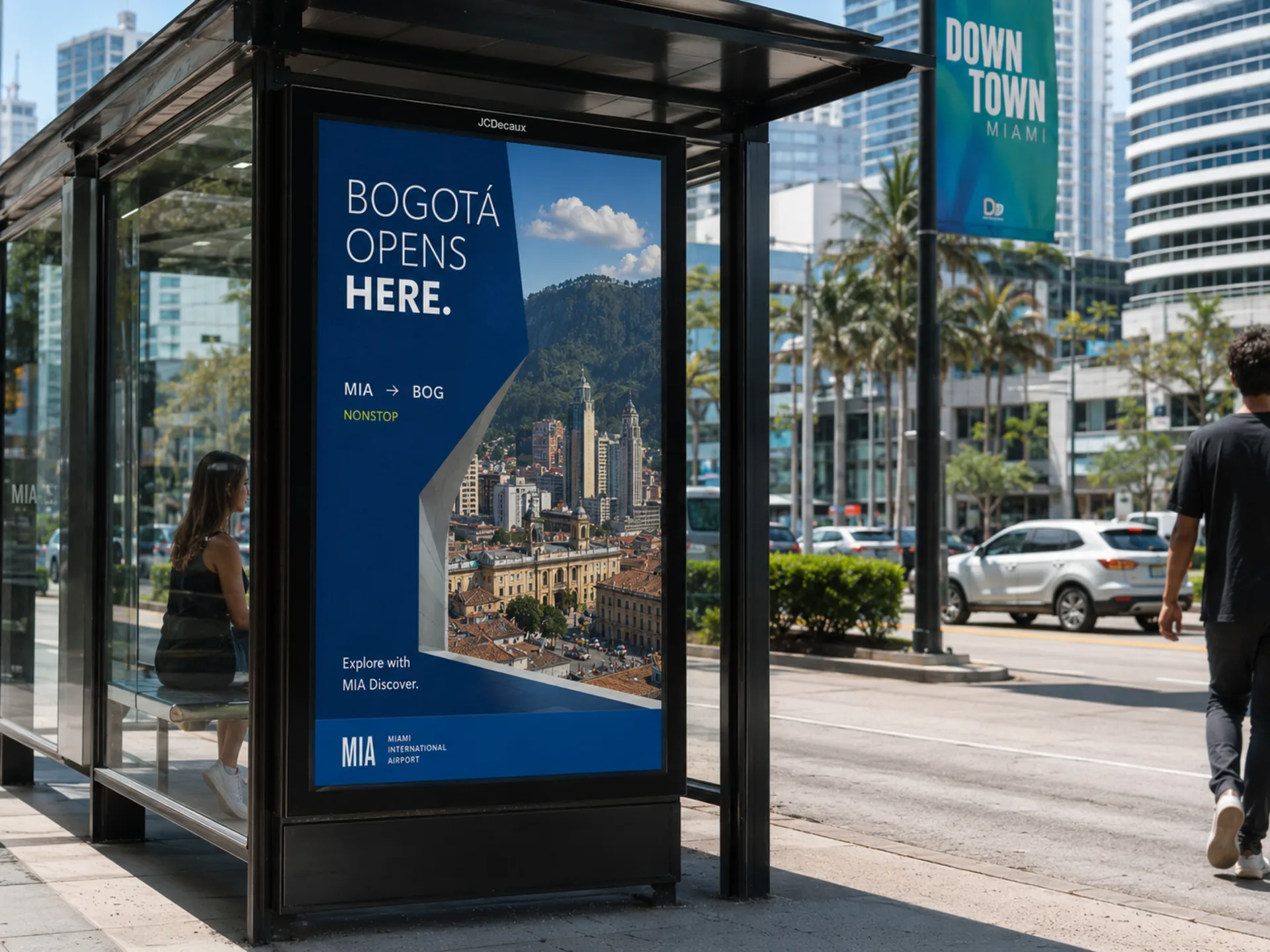 Opens Here — Bogotá Opens Here poster on a downtown Miami bus shelter
