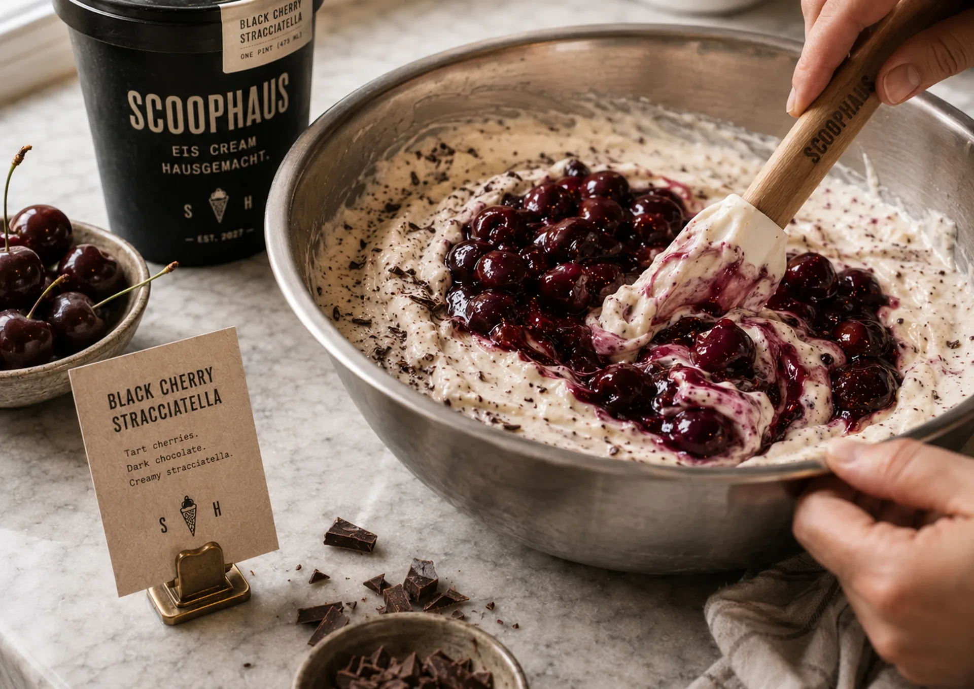 Scoophaus — Black cherry stracciatella ice cream being folded in a mixing bowl beside Scoophaus packaging