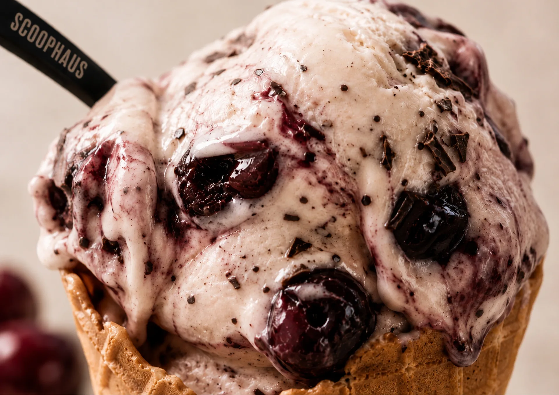 Scoophaus — Close-up Scoophaus ice cream scoop with black cherry pieces in a waffle cone