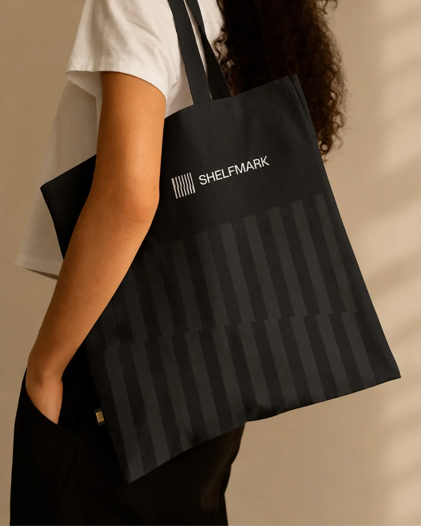 Shelfmark — Black Shelfmark tote bag with white wordmark and tonal vertical shelf pattern