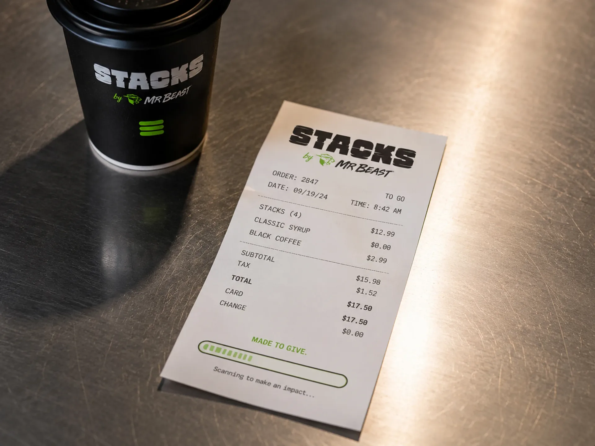 Stacks — Stacks receipt detail beside a black branded coffee cup on a metal counter