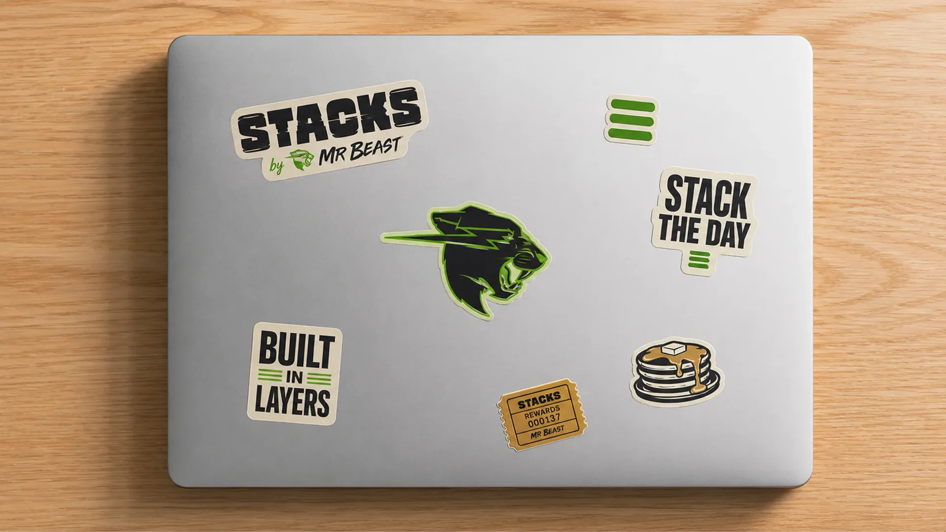 Stacks — Silver laptop covered with Stacks by MrBeast stickers, stack mark, reward ticket, and breakfast illustrations