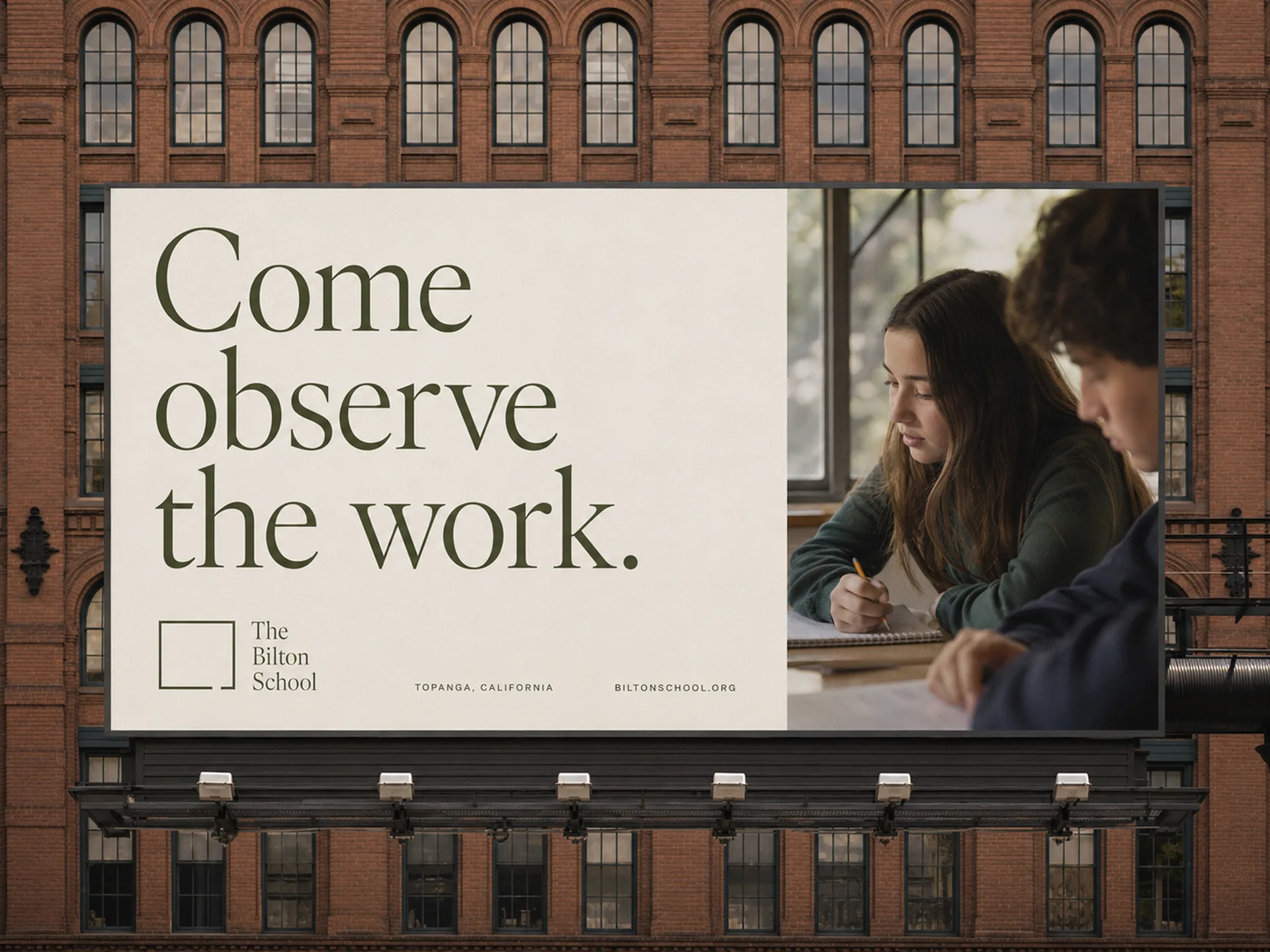 The Bilton School — Billboard reading Come observe the work. with student photography against a brick industrial building